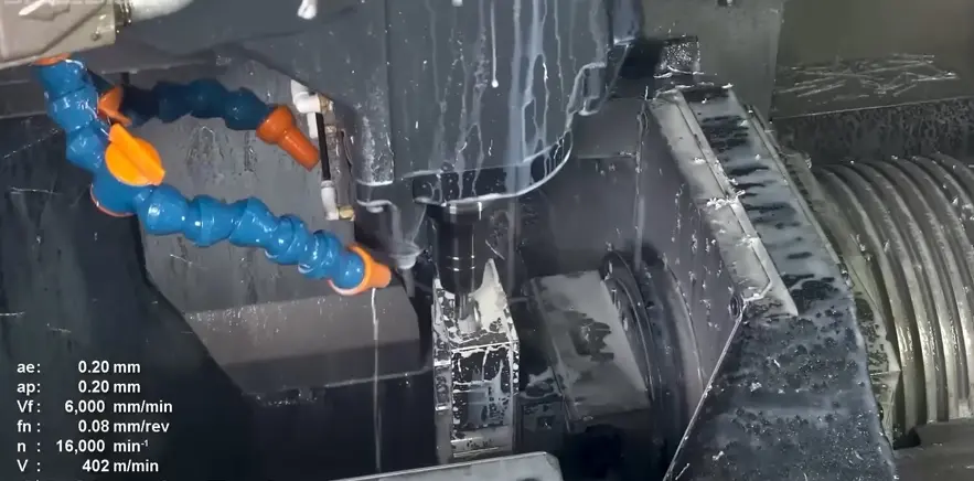 CNC milling machine spindle cutting an aluminum part with coolant flow