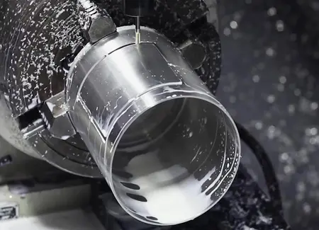Aluminum component undergoing 4-axis CNC machining, showcasing indexed multi-face milling for complex radial features. 