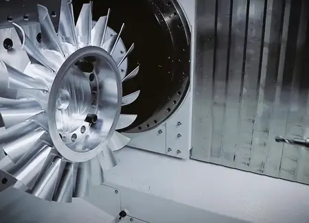 Complex titanium turbine impeller produced via simultaneous 5-axis CNC machining for aerospace applications. 
