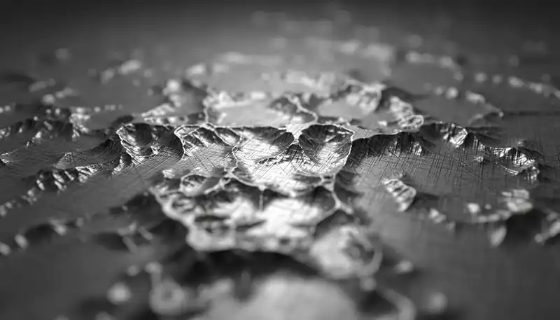 A highly magnified 3D render of a metal surface showing peaks and valleys, illustrating the concept of surface texture.