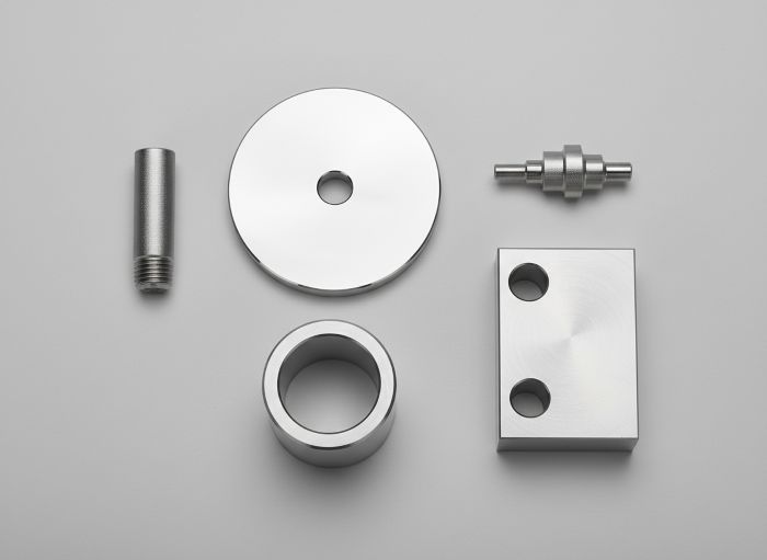 Multiple stainless steel CNC parts showing different surface finishes